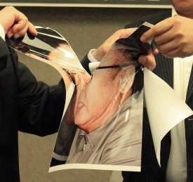 Fotografie Kim Čong-ila na tiskové konferenci.